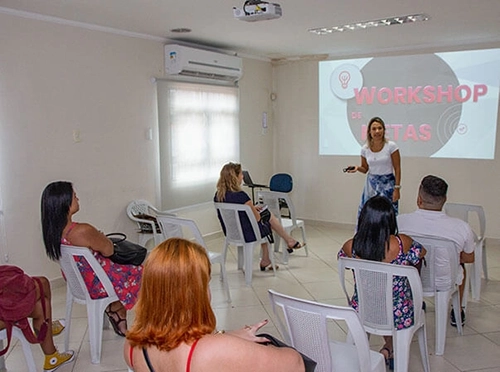imagem de uma sala de treinamento com a a psicóloga rejane calixto dando um workshop sobre metas